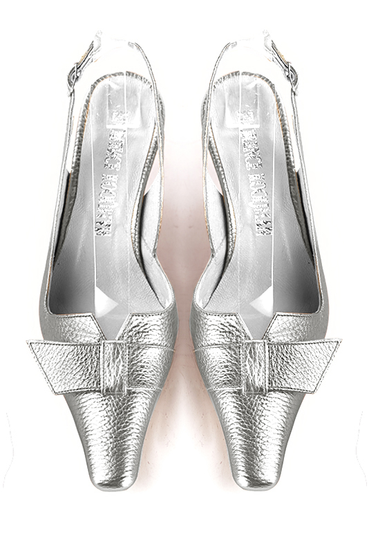 Light silver slingback shoes. Tapered toe. Medium spool heels. Model Cecilia Gao